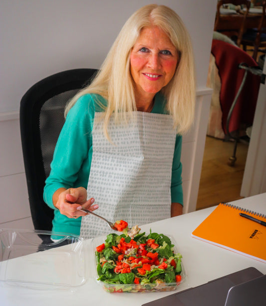 Woman eating lunch during work wearing a Grey Dot NEATsheet.