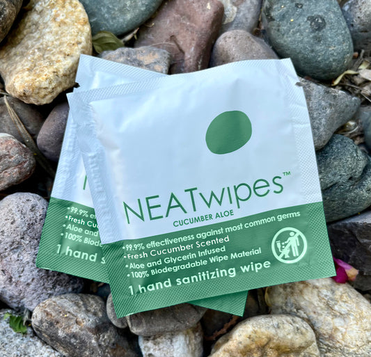 NEATwipes handwipe with Cucumber Aloe scent on a background of rocks.