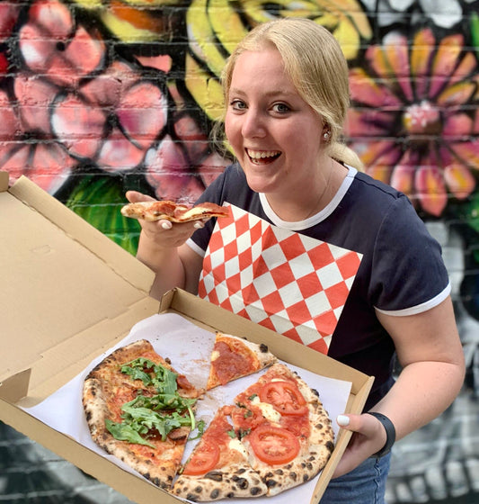 Madie Augusto, NEATGOODS intern, eating pizza while donning a NEATsheet.