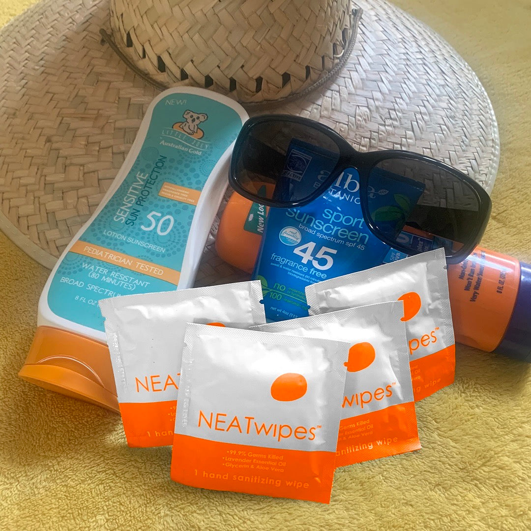 Individually wrapped NEATwipes Fresh Citrus hand wipes with beach accessories.