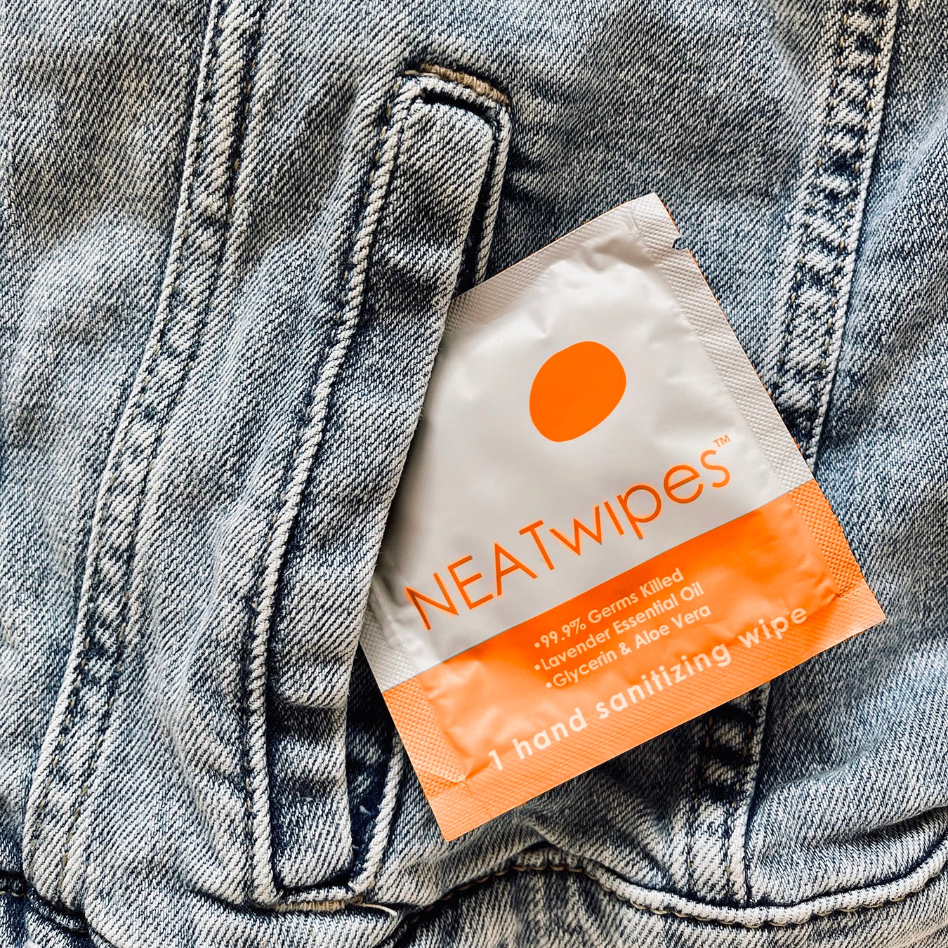Individually wrapped NEATwipes Fresh Citrus hand wipe in a denim jean pocket.