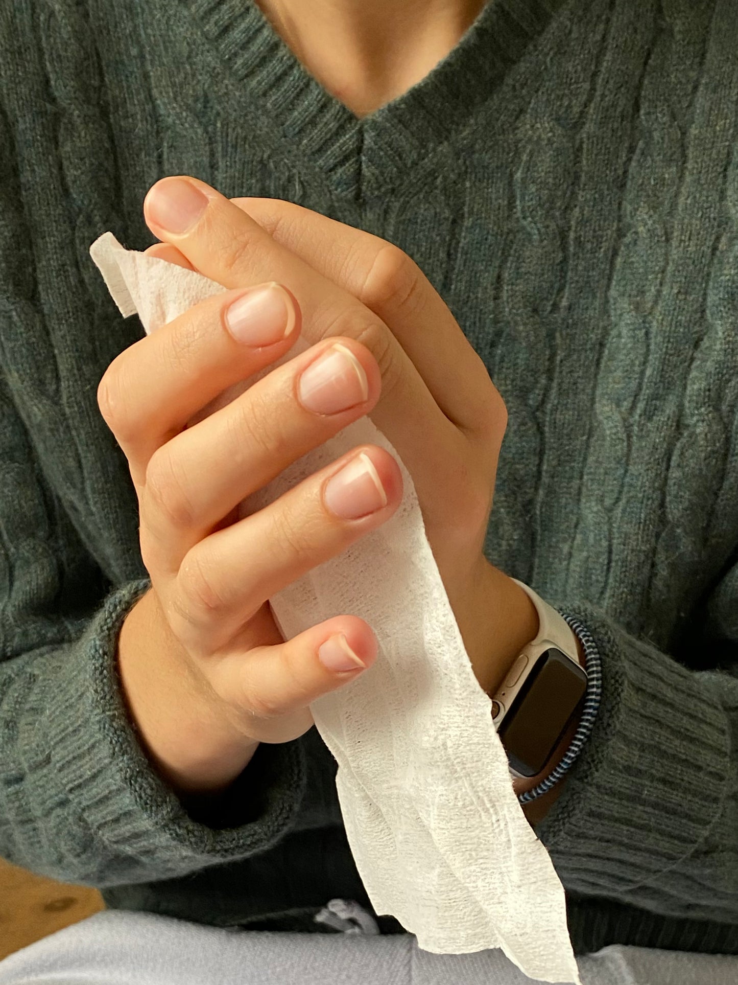 A woman using a NEATwipes Lavender hand wipe.