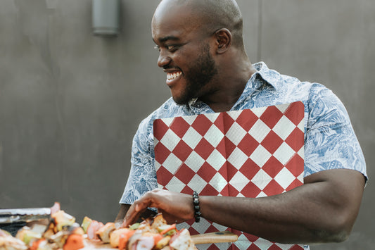 Man eating barbecue wearing a red and white diamond NEATsheet.