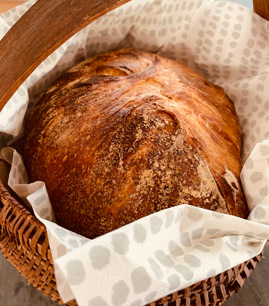 Bread loaf in basket lined with a Grey Dot NEATsheet.