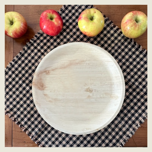 A NEATtable compostable wood plate on a placemat. 