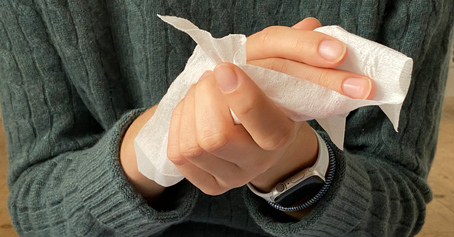 Woman wiping her hands with NEATwipes handwipe.