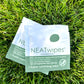 Individually wrapped NEATwipes Cucumber Aloe hand wipes on grass..