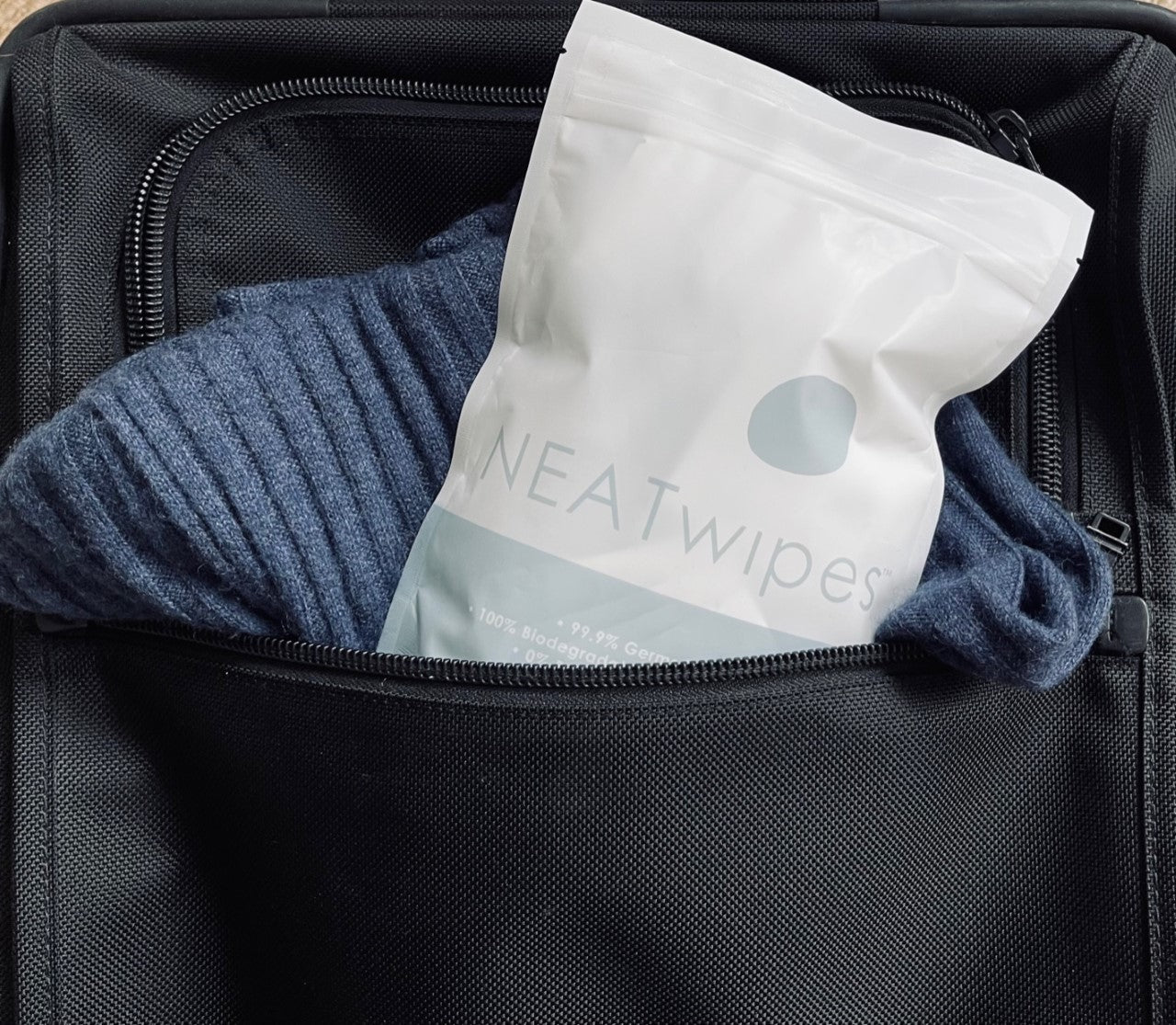 A pouch of NEATwipes hand wipes in a travel bag.