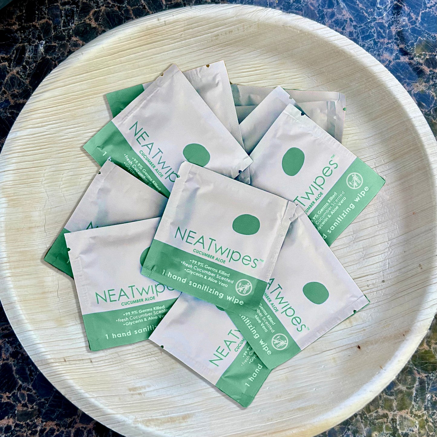NEATwipes Cucumber Aloe hand wipes on a plate.